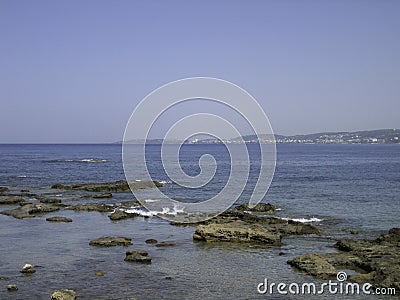 Weak waves gently wash the stones lying on the shallow bottom of the sea rocky shore in good weather Stock Photo