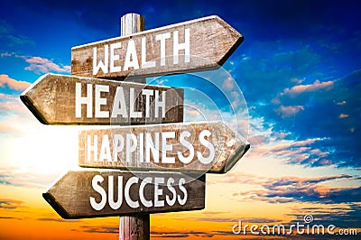 Wealth, health, happiness, success - wooden signpost, roadsign with four arrows Stock Photo