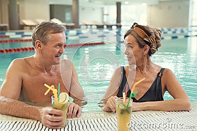 Wealthy Senior Couple in Swimming Pool Stock Photo