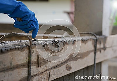 Wear glove hand of industrial bricklayer hold aluminium brick trowel installing mortar wall on construction site Stock Photo