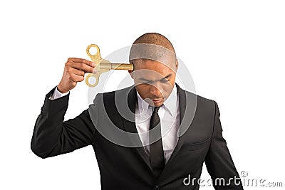 Weary businessman recharge himself with a key due to overwork Stock Photo