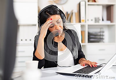 Weary woman with microphone headset at work in office Stock Photo