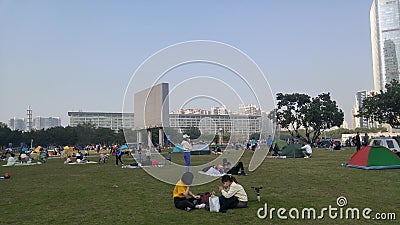 Shenzhen, China: it`s sunny and warm. Citizens relax on the park lawn, some set up tents, and the family is enjoying their leisure Editorial Stock Photo