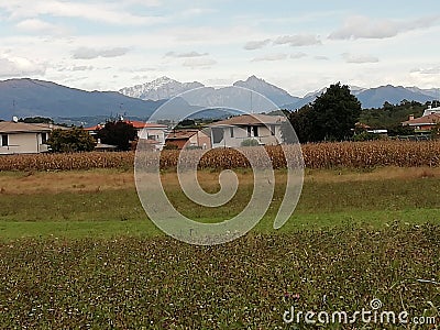 Weather over the alps in farmlands landscape in italy Stock Photo
