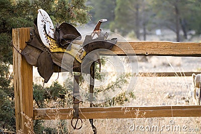 Weathered Antique Saddle on Fence Stock Photo