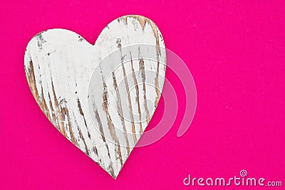 Weathered heart on bright pink textured felt material Stock Photo