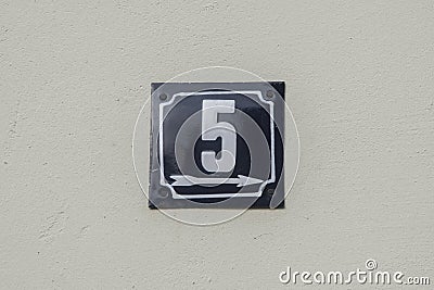 Weathered metal enameled plate of street address number 5 Stock Photo