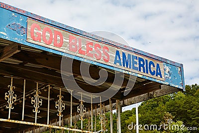 Weathered Patriotic Sign, Rustic Americana, Green Foliage Background Stock Photo