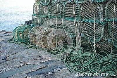 Weathered prawn traps piled on a dock in western Scotland Stock Photo