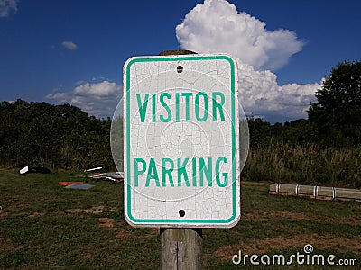 Weathered white and green visitor parking sign Stock Photo