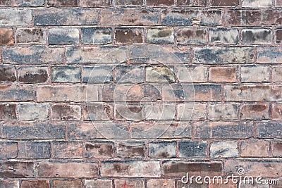 A weathered worn red stone wall in closeup Stock Photo