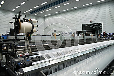 Weaving automatic machines - Weaving is a method of textile production in which two distinct sets of yarns or threads are Stock Photo