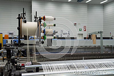 Weaving automatic machines - Weaving is a method of textile production in which two distinct sets of yarns or threads are Stock Photo