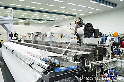 Weaving automatic machines - Weaving is a method of textile production in which two distinct sets of yarns or threads are Stock Photo