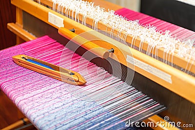 Weaving shuttle on the color warp in weaving machine Stock Photo