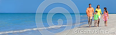 Web banner panoramic happy family of mother, father and two children, son and daughter, walking on a beach Stock Photo