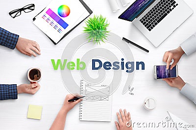 Web design text on work desk surrounded with web development team Stock Photo