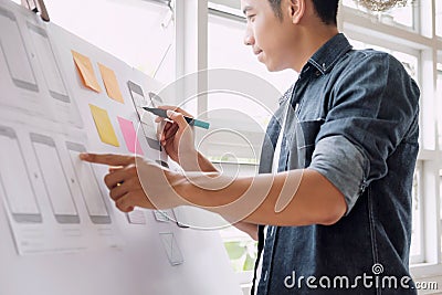 Web designer planning application for mobile phone. Stock Photo