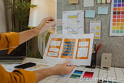 A web developer, as a User Experience and User Interface Officer, is designing beautiful and easy-to-use digital products that Stock Photo