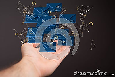 Web of illustrative 3D rendered blue envelope icons floating on a man's palm on a black background Stock Photo