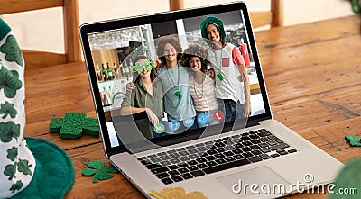 Webcam view of group of friends at a bar on video call on laptop on wooden table Stock Photo