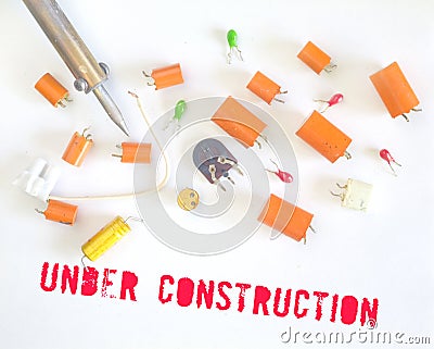 Website under construction sign with defective capacitors and soldering iron Stock Photo