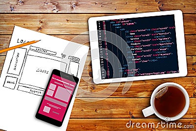 Website wireframe sketch and programming code on digital tablet Stock Photo