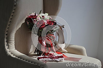 A bride`s bouquet of red and pink roses, women`s shoes, a garter of the bride Stock Photo