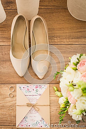 Wedding accessories: bridal shoes, rings, invitation, rings. Wedding details in beige shades. View from above Stock Photo