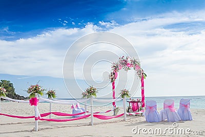 Wedding arch decorated with flowers on tropical beach, outd Stock Photo