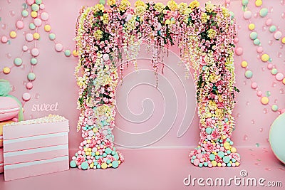 Wedding arch indoors. Festive decorations with flowers and colorful balloons on pink background Stock Photo