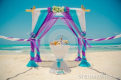 Wedding archway are arranged on the sand in preparation for a beach wedding ceremony. Stock Photo