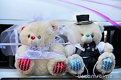 Wedding bears in the form of the bride and groom decorate the wedding car Stock Photo