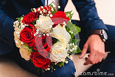 Wedding bouquet for the bride from white and beige roses to the groom`s hand Stock Photo