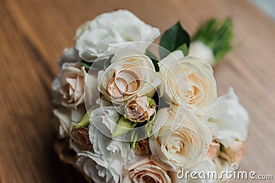 Wedding bouquet of fresh flowers, a pair of gold rings close-up. Wedding details Stock Photo