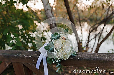 Wedding bouquet of fresh flowers, a pair of gold rings close-up. Wedding details Stock Photo