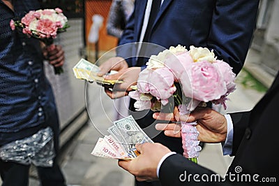 Wedding bouquet of peony at hands of groom with moneys. Redemption of bride on wedding Stock Photo