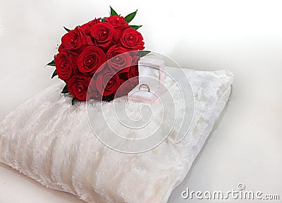 A wedding bouquet of red roses lies on a white pillow Stock Photo