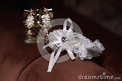 Wedding bride garter and gold earrings Stock Photo