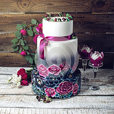 Wedding cake ornamented in rustic style blue and purple roses Stock Photo