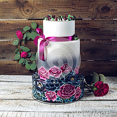 Wedding cake ornamented in rustic style blue and purple roses Stock Photo