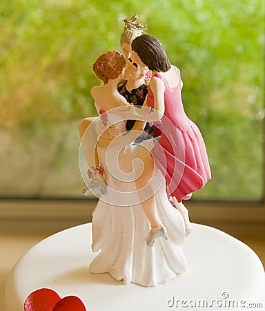 Wedding Cake Topper Depicting One Man with Several Women Stock Photo