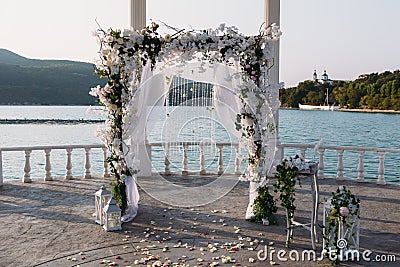 Wedding ceremony arch it the beautiful lake place. Details of decoration Stock Photo