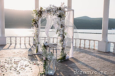 Wedding ceremony arch it the beautiful lake place. Details of decoration Stock Photo