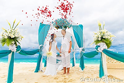 Wedding ceremony on a tropical beach in blue. Happy groom and br Stock Photo