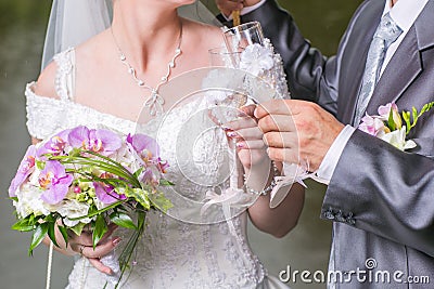 Wedding glasses in hands of groom and bride Stock Photo