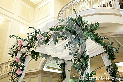 Wedding chuppah decorated with fresh flowers indoor banquet hall of wedding ceremony. Luxury wedding florist decoration artwork Stock Photo