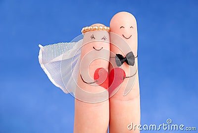 Wedding concept - newlyweds painted at fingers against blue sky Stock Photo