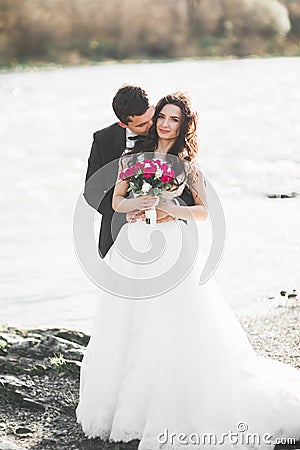 Wedding couple, groom and bride hugging, outdoor near river Stock Photo