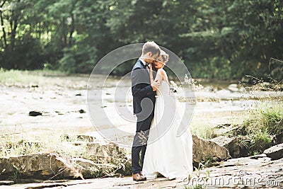 Wedding couple, groom and bride hugging, outdoor near river Stock Photo